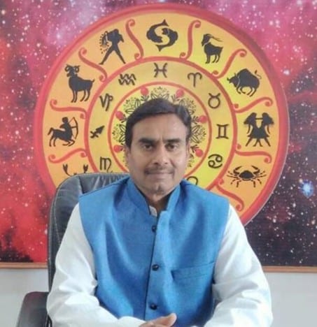 Shri Ravindra Vishwakarma, Vedic astrologer, seated before a zodiac wheel